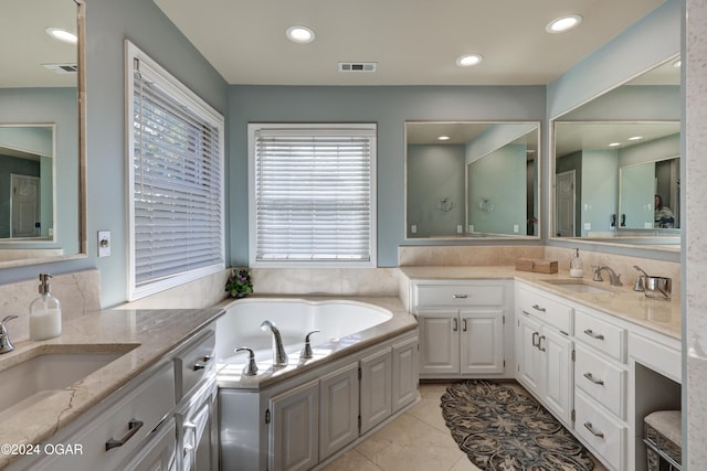 bathroom with vanity, decorative backsplash, and a tub to relax in