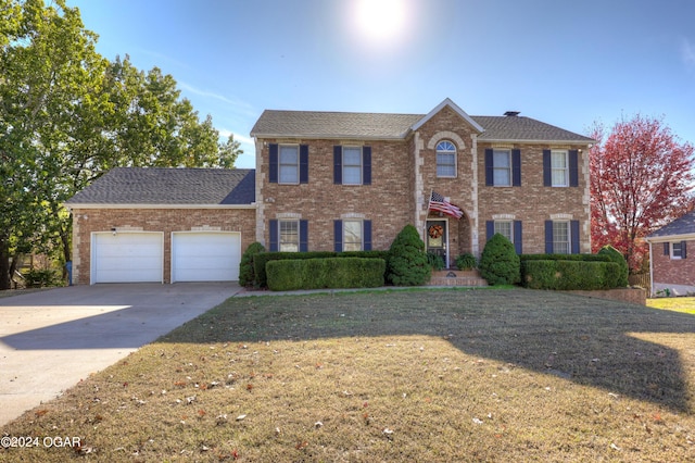 colonial house with a front yard and a garage