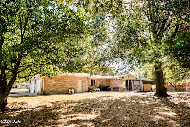 410 N Eisenhower St, Monett, MO 65708 - back of house with a storage unit, an outbuilding, and an attached garage