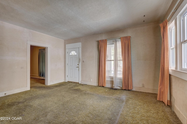 carpeted foyer featuring a textured ceiling