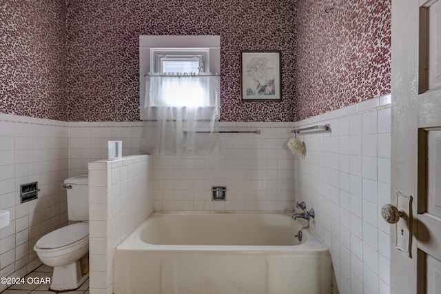 bathroom with toilet, tile walls, and a washtub