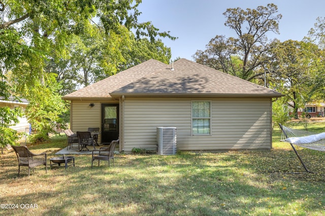 rear view of house featuring a yard and a fire pit