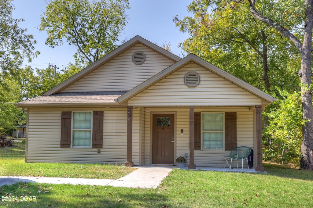 view of front of house featuring covered porch and a front lawn