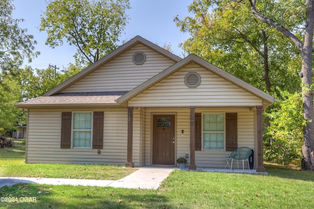 view of front of house featuring covered porch and a front lawn