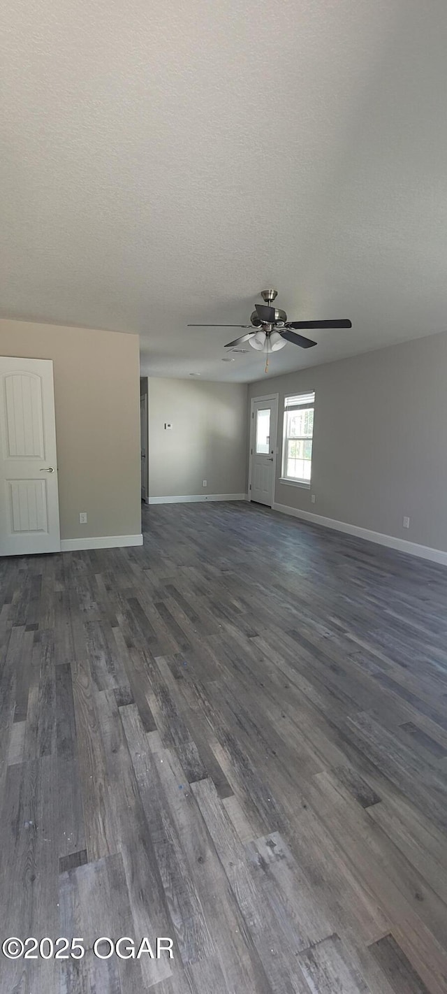 unfurnished room with ceiling fan, dark wood-type flooring, and a textured ceiling