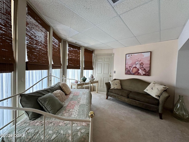 carpeted living room with a paneled ceiling