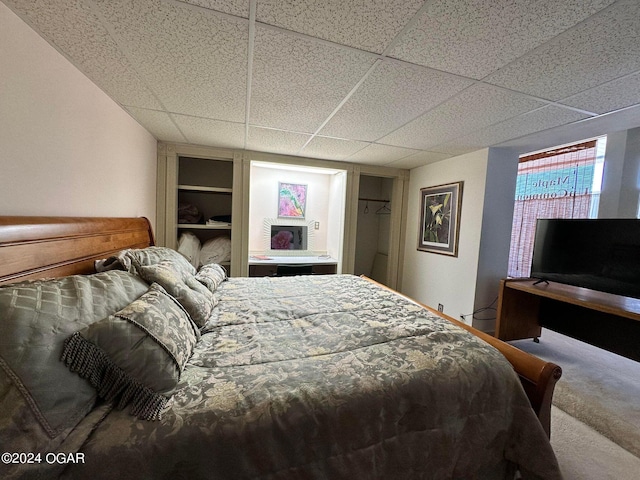 bedroom featuring a paneled ceiling and carpet flooring