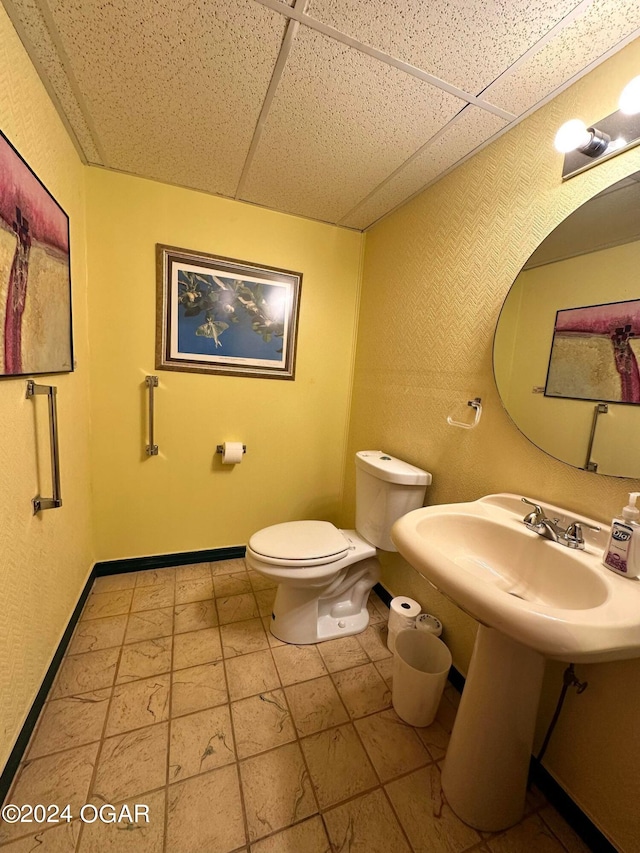 bathroom with toilet and a paneled ceiling