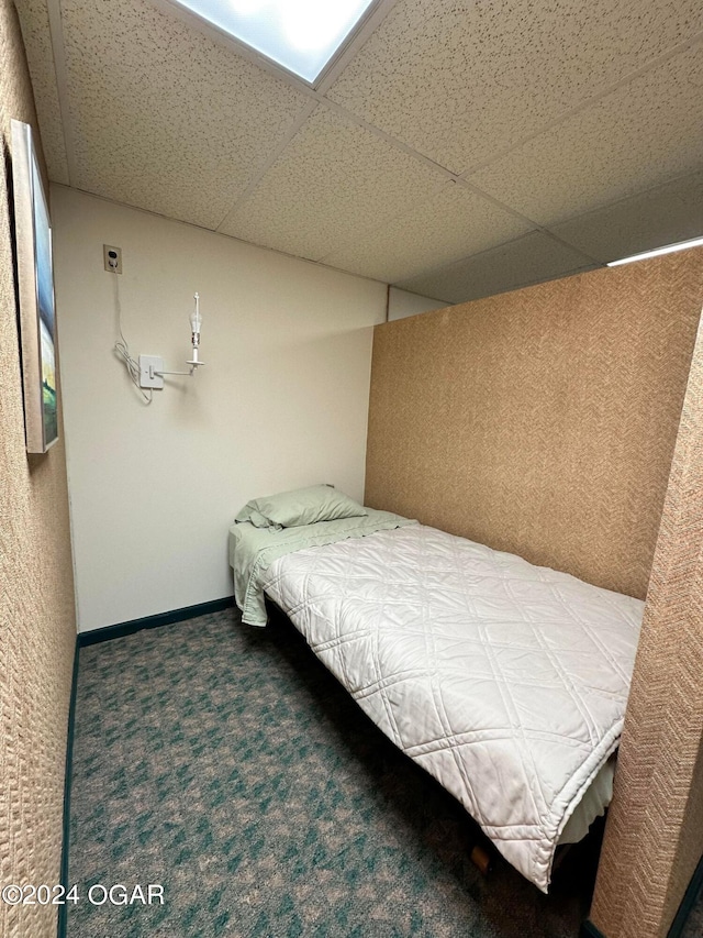 unfurnished bedroom featuring carpet and a paneled ceiling