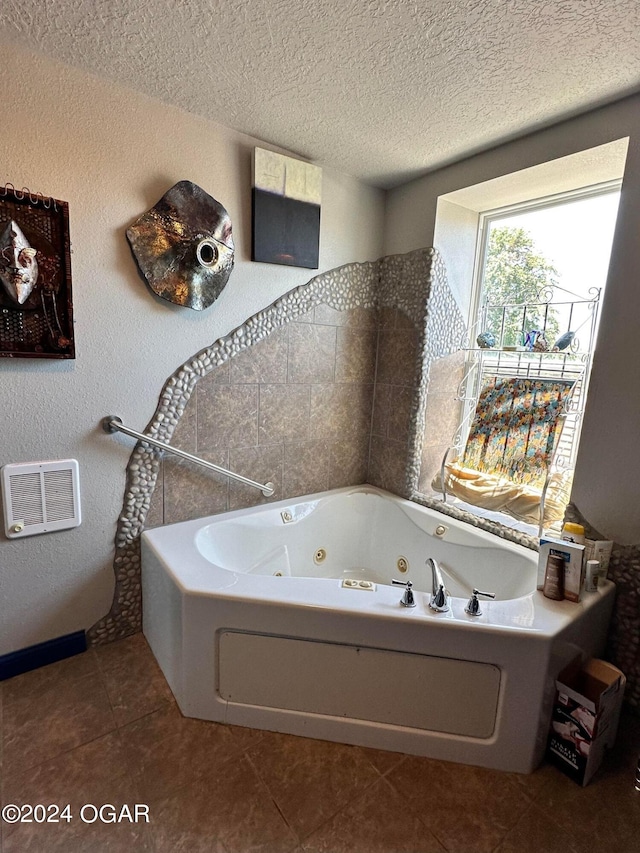 bathroom featuring a bathtub, a textured ceiling, and tile patterned flooring