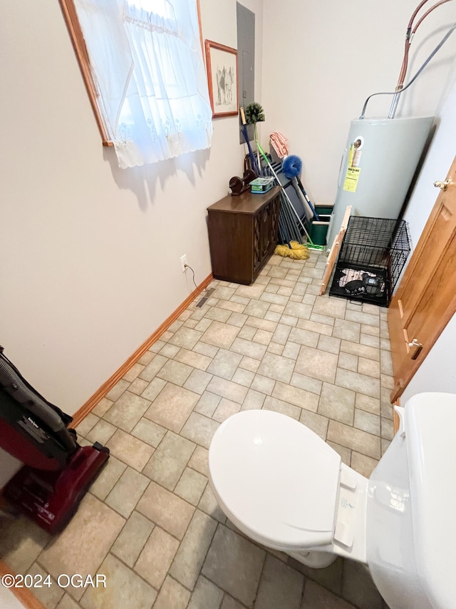 bathroom with electric water heater, electric panel, and toilet