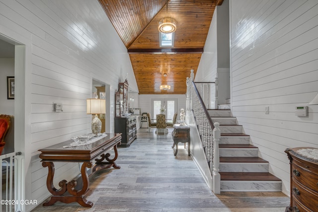 staircase with high vaulted ceiling, hardwood / wood-style flooring, wooden ceiling, and wooden walls