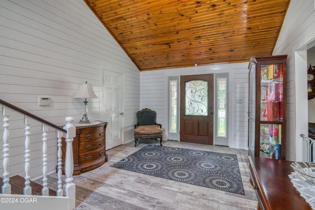 foyer entrance featuring light hardwood / wood-style floors, high vaulted ceiling, wooden walls, and wooden ceiling