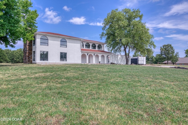 view of front facade featuring a balcony and a front lawn