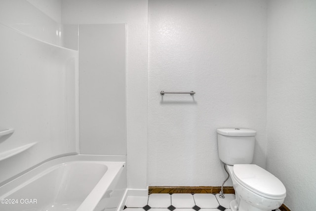 bathroom featuring tile patterned flooring, a washtub, and toilet