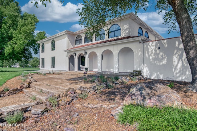 mediterranean / spanish home featuring a porch