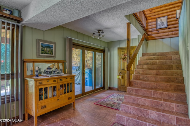 entrance foyer featuring french doors and a textured ceiling