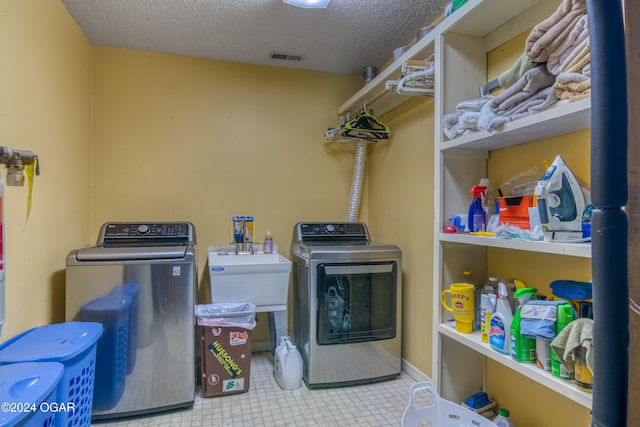 laundry area with washer and dryer and a textured ceiling