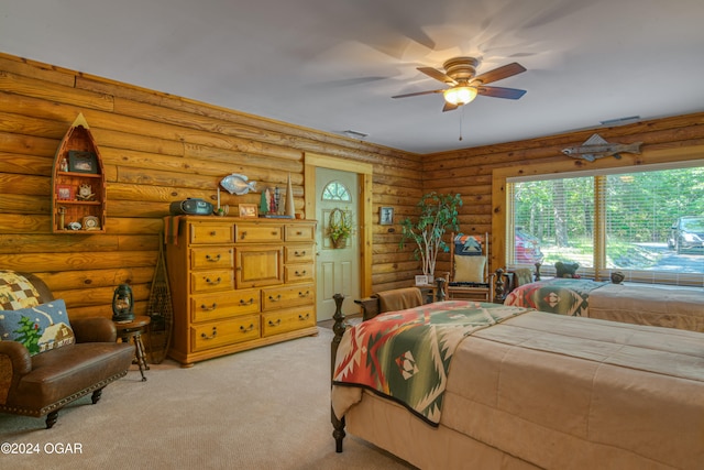 bedroom with rustic walls, light colored carpet, and ceiling fan