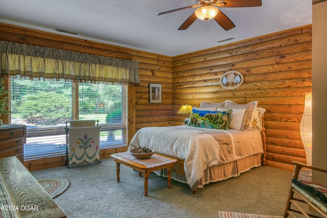 bedroom with log walls, carpet, and ceiling fan