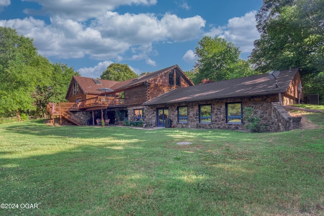 rear view of house with a deck and a lawn