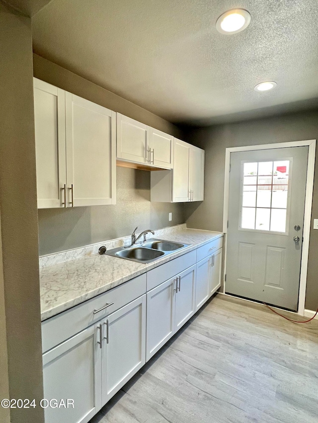 kitchen featuring light wood-type flooring and white cabinets