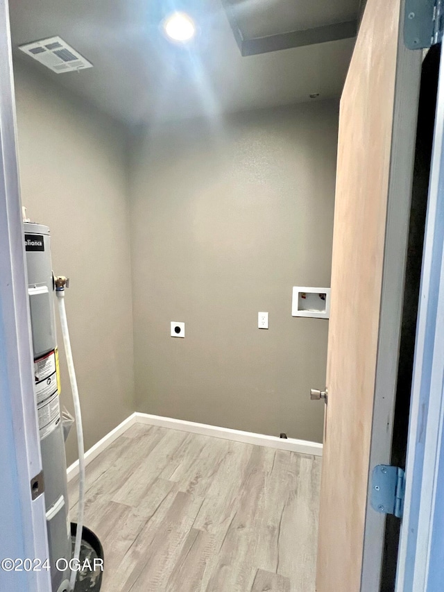 laundry area featuring hookup for an electric dryer, electric water heater, light hardwood / wood-style flooring, and hookup for a washing machine