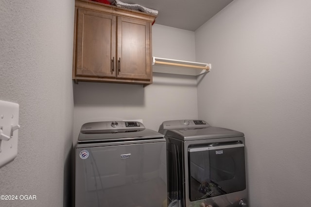 washroom featuring cabinets and independent washer and dryer