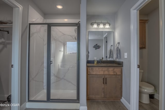 bathroom featuring a shower with door, toilet, wood-type flooring, and vanity