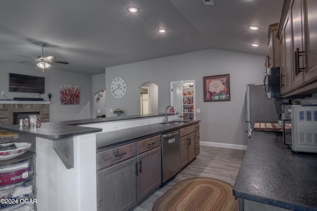 kitchen featuring sink, a kitchen breakfast bar, ceiling fan, light hardwood / wood-style floors, and stainless steel appliances