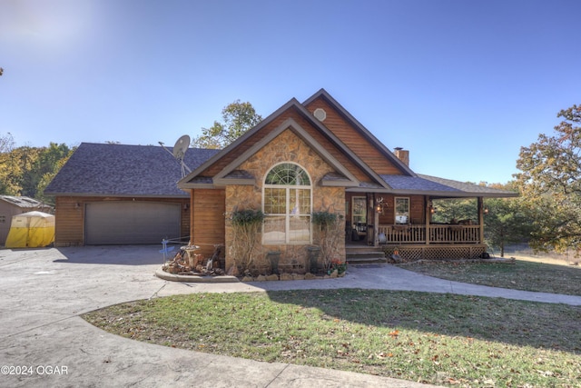 view of front of house featuring covered porch, a garage, and a front lawn