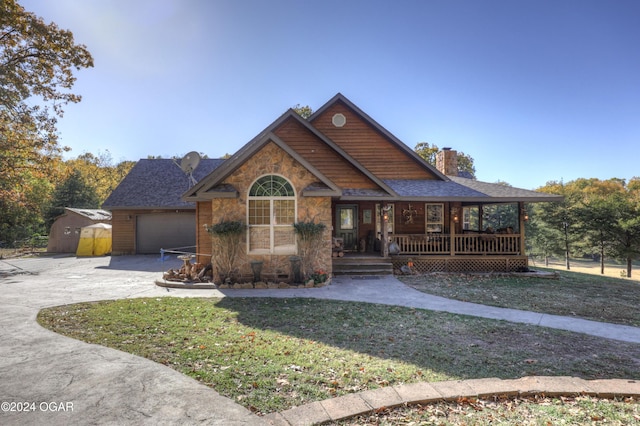 view of front of property with covered porch, a front yard, and a garage