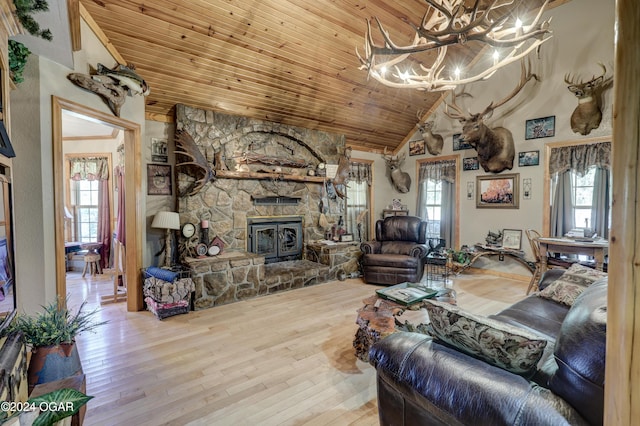 living room with a wood stove, hardwood / wood-style flooring, lofted ceiling, and wood ceiling