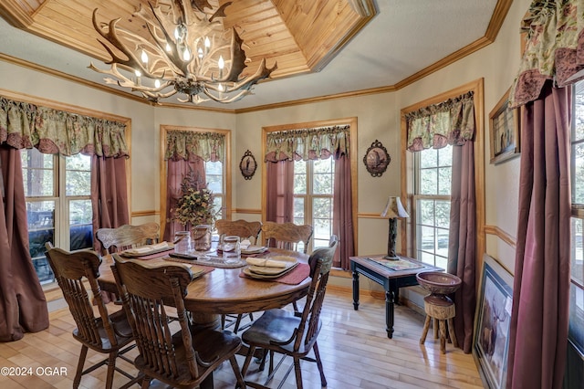 dining room featuring a notable chandelier, ornamental molding, light wood-type flooring, and a wealth of natural light