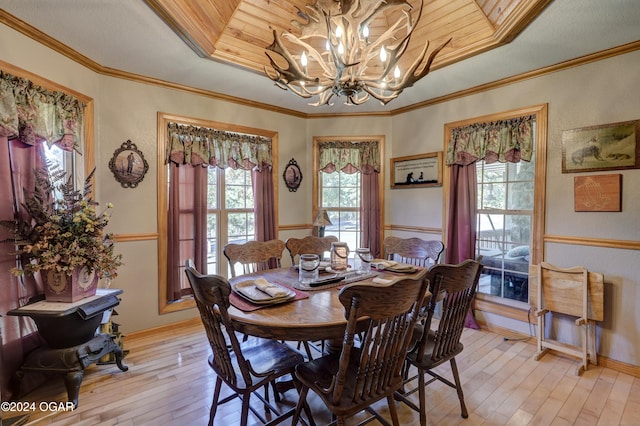 dining space featuring light hardwood / wood-style floors, crown molding, an inviting chandelier, and plenty of natural light