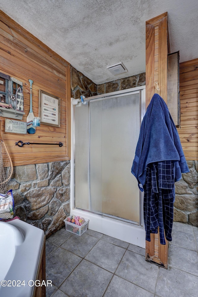 bathroom featuring wooden walls, a textured ceiling, and shower with separate bathtub