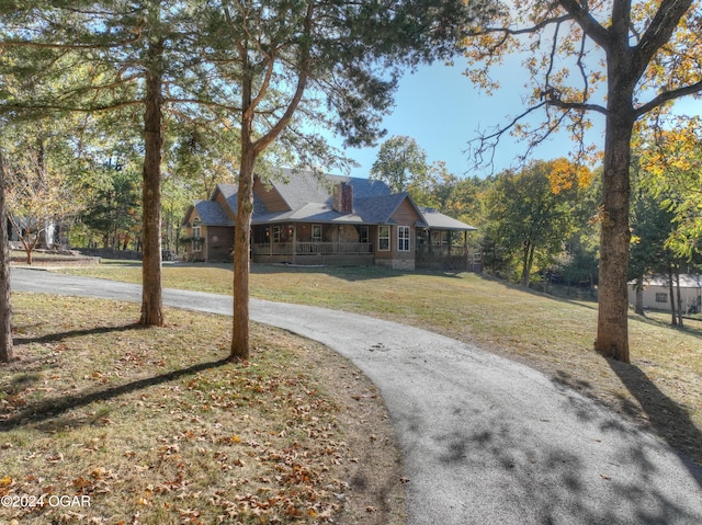 view of front of home with covered porch and a front lawn