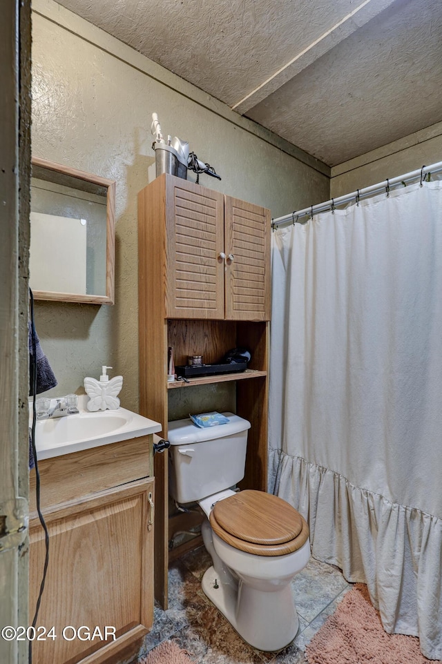 bathroom with vanity, toilet, a textured ceiling, and curtained shower