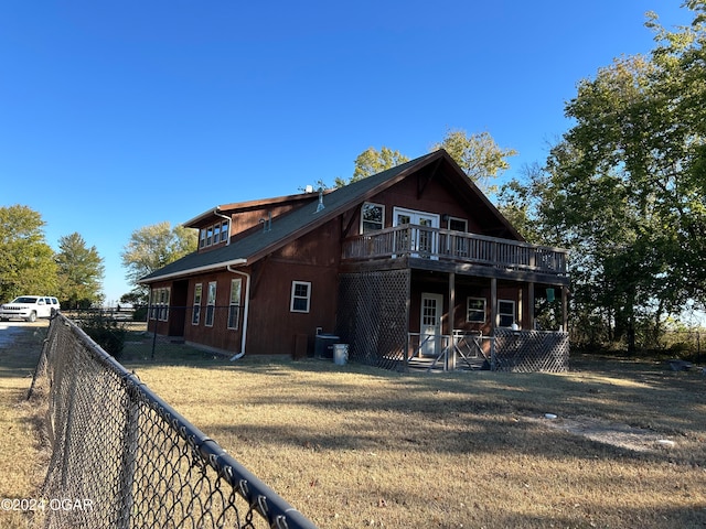 rear view of property with a yard and a deck