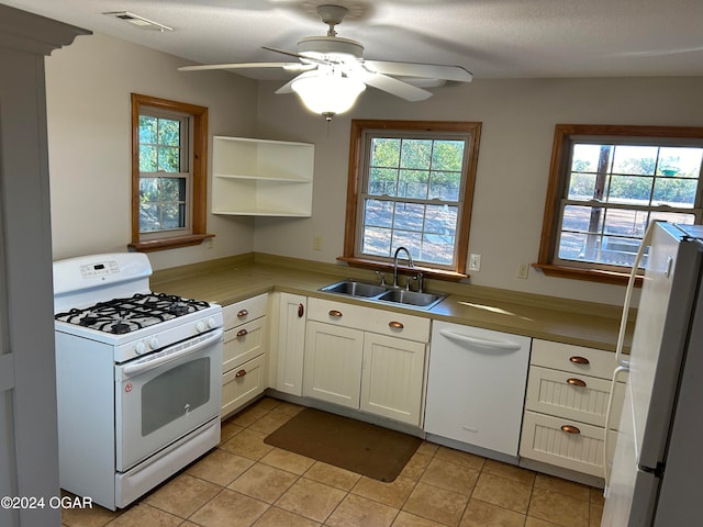 kitchen featuring white appliances, sink, and plenty of natural light