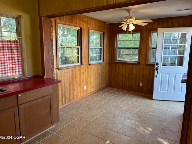 unfurnished sunroom with ceiling fan and a wealth of natural light