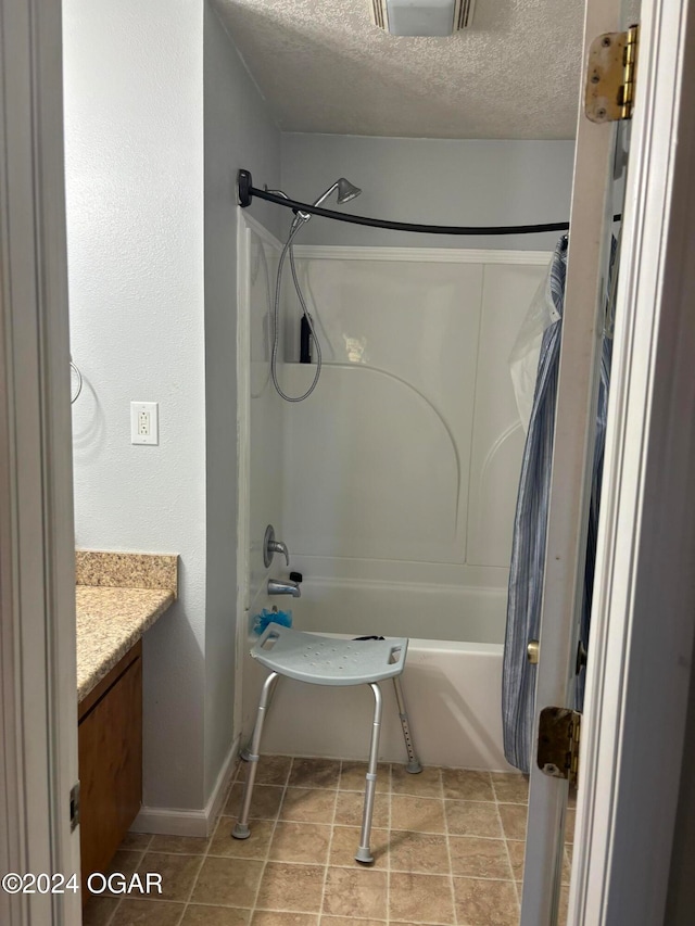 bathroom with vanity, shower / bath combo with shower curtain, and a textured ceiling