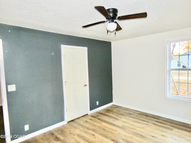 spare room featuring ceiling fan, a textured ceiling, and light hardwood / wood-style flooring