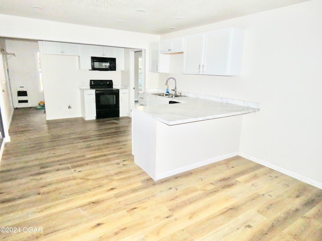 kitchen featuring black appliances, light hardwood / wood-style flooring, and white cabinetry