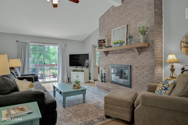 living room featuring light wood-type flooring, a brick fireplace, ceiling fan, beamed ceiling, and high vaulted ceiling