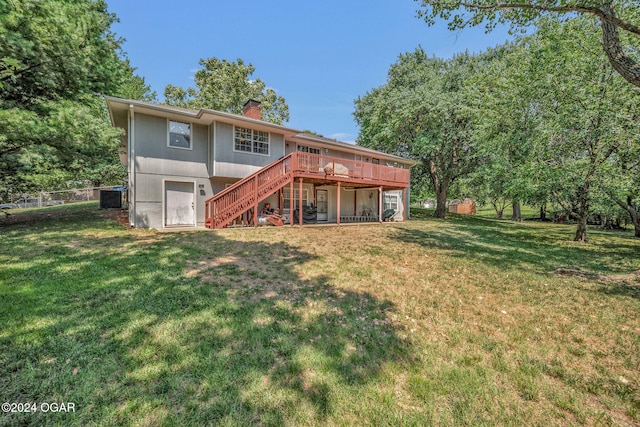 rear view of property featuring cooling unit, a deck, and a lawn