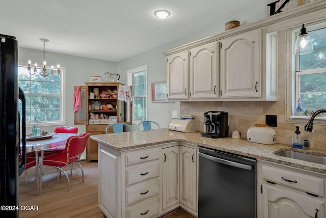 kitchen featuring kitchen peninsula, sink, an inviting chandelier, stainless steel dishwasher, and light hardwood / wood-style floors