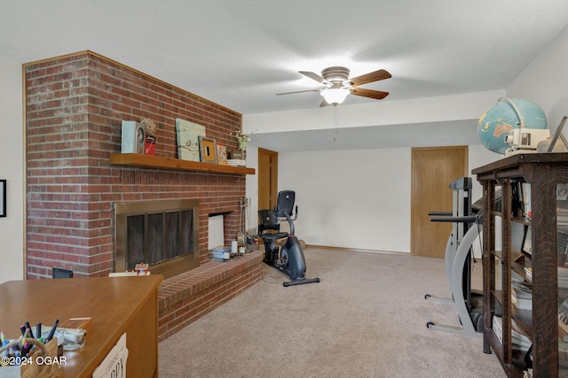 workout area featuring a textured ceiling, a brick fireplace, carpet flooring, and ceiling fan