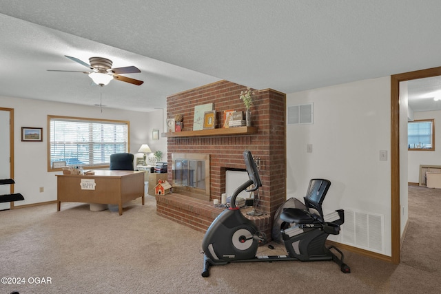 interior space with a fireplace, light carpet, a textured ceiling, and ceiling fan