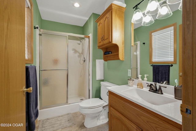 bathroom with toilet, tile patterned flooring, vanity, a chandelier, and an enclosed shower